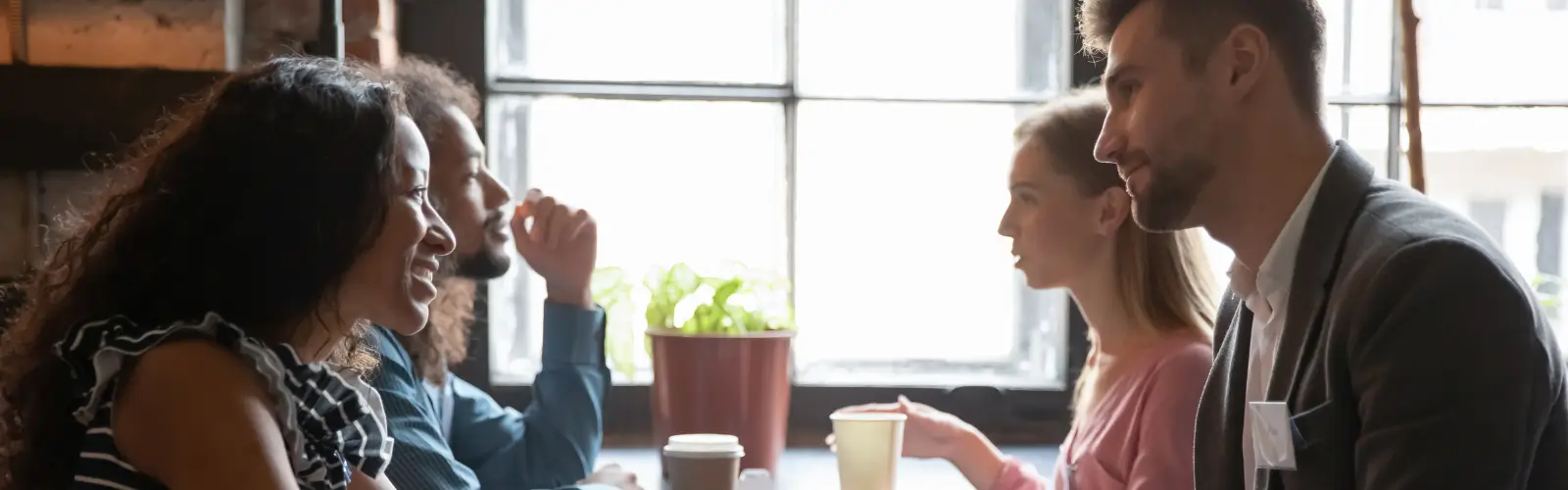 speed-dating-cafe-gruppe-gespraech Zwei Paare sitzen in einem CafĂ© und unterhalten sich beim Speed-Dating â Kennenlernen in entspannter AtmosphĂ€re.